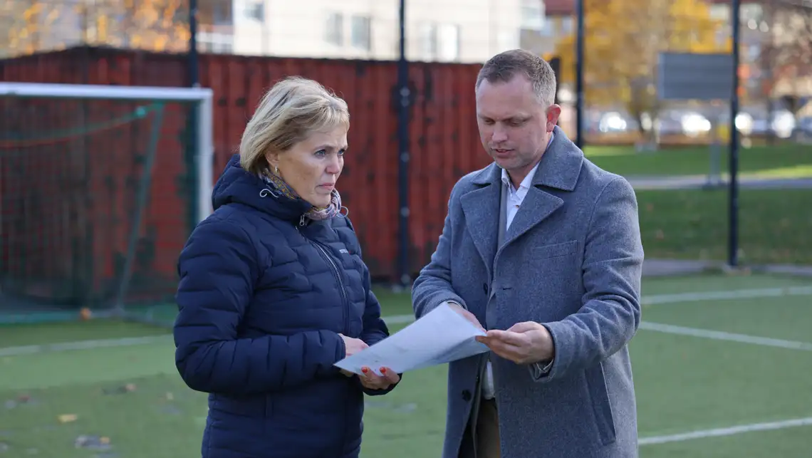 Elisabeth och Stefan står i Berga aktivitespark och tittar på en ritning.