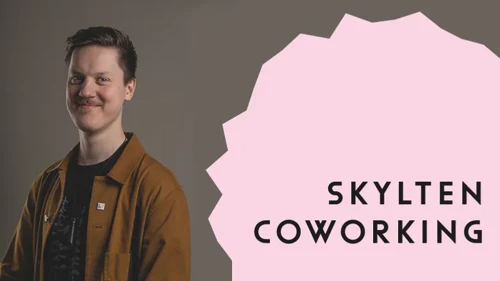 Foto av en leende man och ett rosa fält med texten Skylten Coworking
