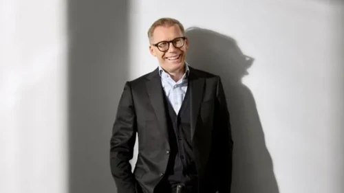 Leeende man i kostym och mörka glasögon
