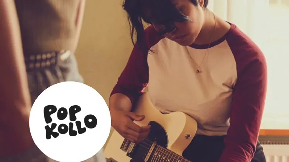 En ung person spelar på en elgitarr