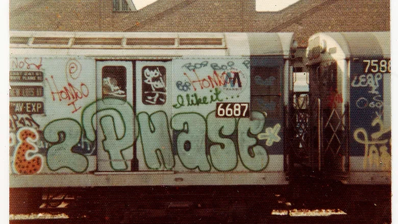 Två grå tågvagnar fulla med graffiti