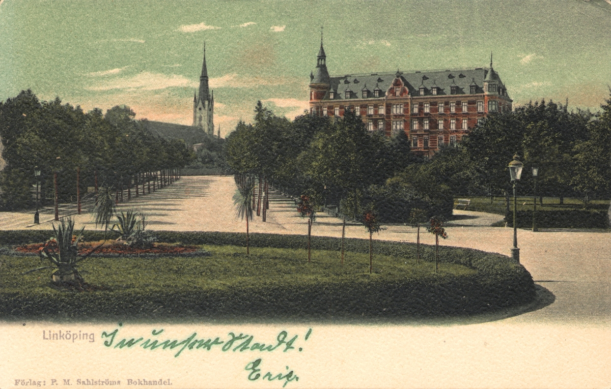 Äldre vykort på Järnvägsparken. Grönskande park, med hus i bakgrunden.