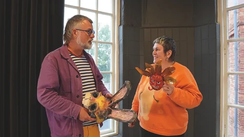 En man och en kvinna som håller i varsin maskeradmask
