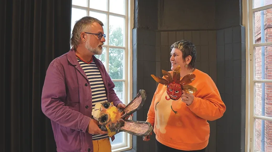 En man och en kvinna som håller i varsin maskeradmask
