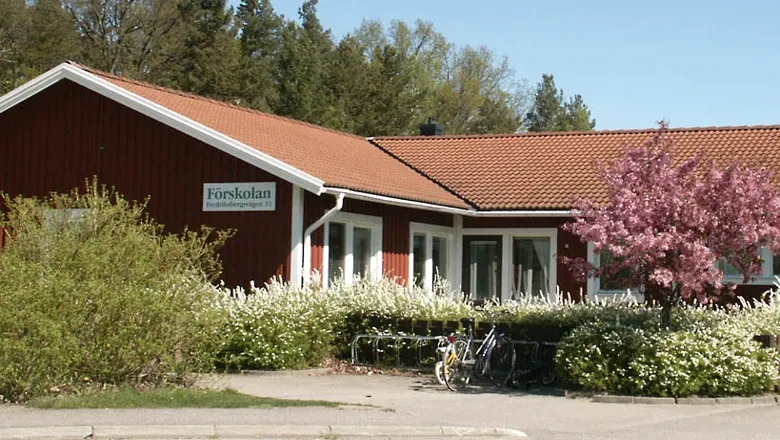 Förskolan Fredriksbergsvägen 31, rött hus med blommande buskar framför