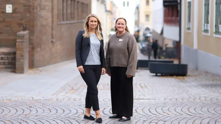 Vesna och Sara står på en kullerstensgata. I bagrunden skymtar ST Lars kyrkotorn