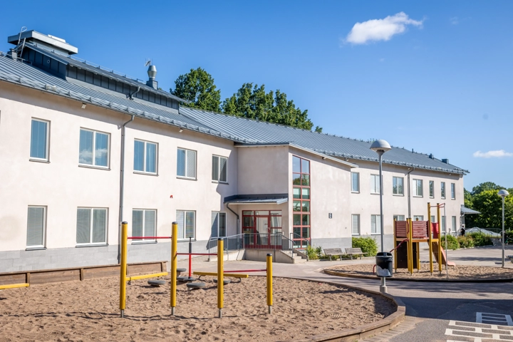 En byggnad med en lekplats framför sig.
