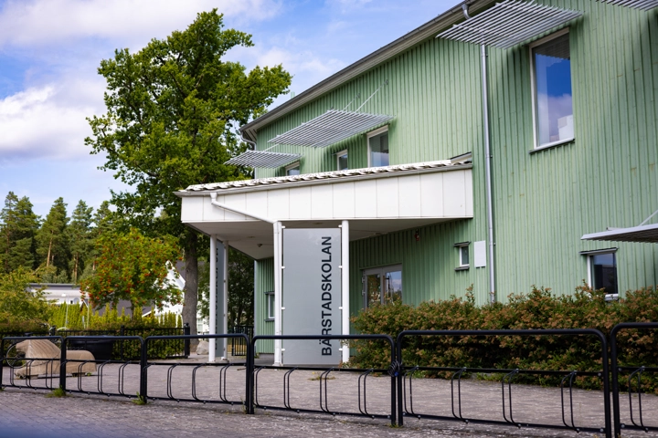 En grön byggnad med ett cykelställ framför.