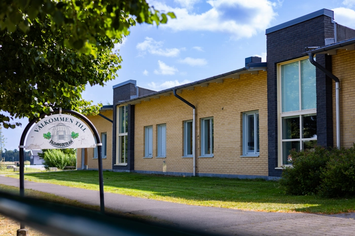 En tegelbyggnad med en skylt framför sig.