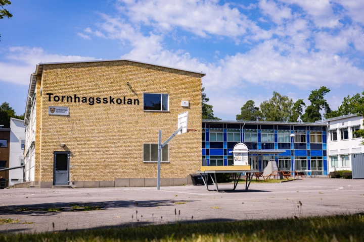 En tegelbyggnad med en basketkorg framför sig.