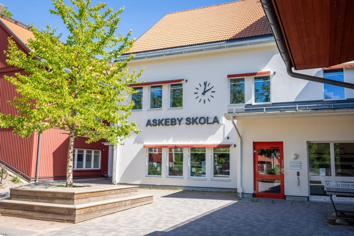 En vit byggnad med en klocka på fasaden.