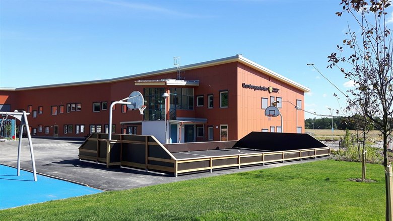 Norrbergaskolan och Bigaråvägens förskola med basketplanen och gungställning i förgrunden