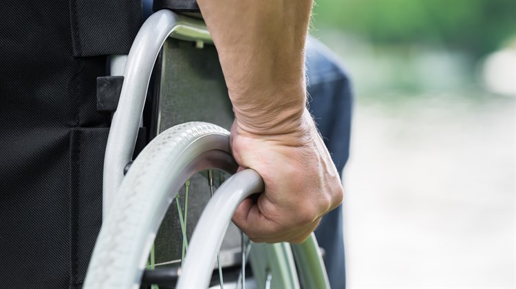 En hand håller i en rullstol