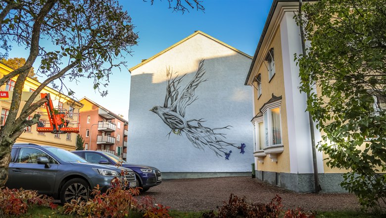 Fågel målad på sidan av lägenhetshus