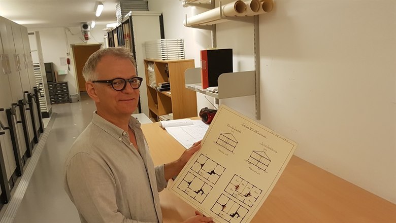 Göran Tagesson visar upp en fin ritning på Stadsarkivet. 