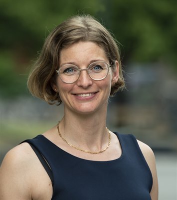 Sara Bäckström, ekonomichef på Utbildningsförvaltningen, står utomhus och ler in i kameran.