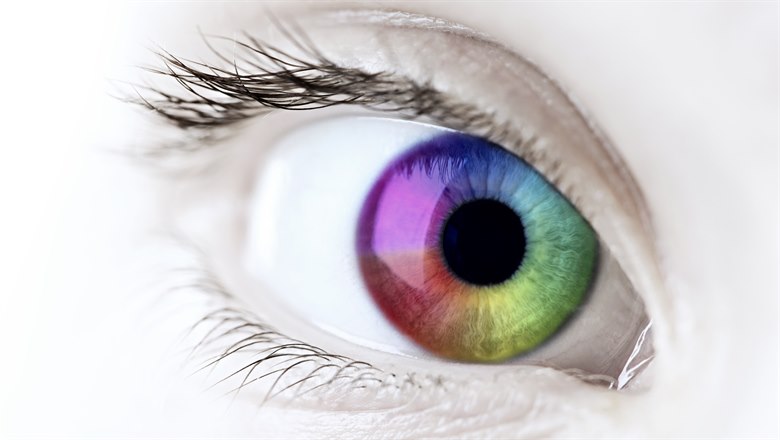 Närbild på ett öga med iris i regnbågsfärger