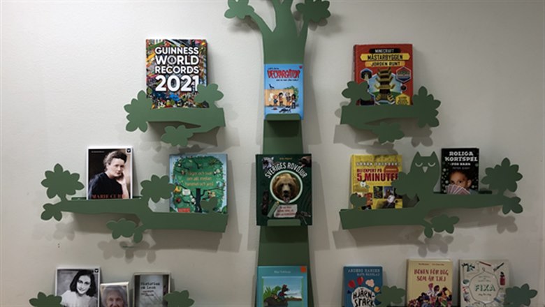 En trädformad bokhylla med böcker.