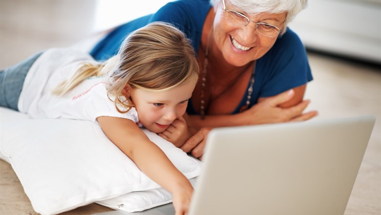 Barn och äldre på golvet med dator