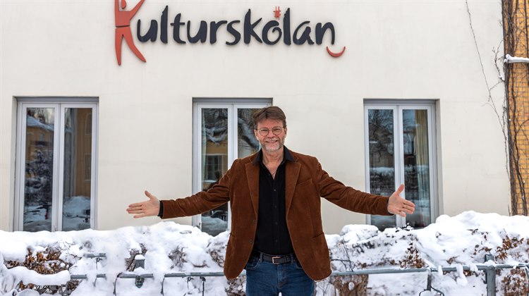 Man står med utsträckta armar framför Kulturskolan i Linköping